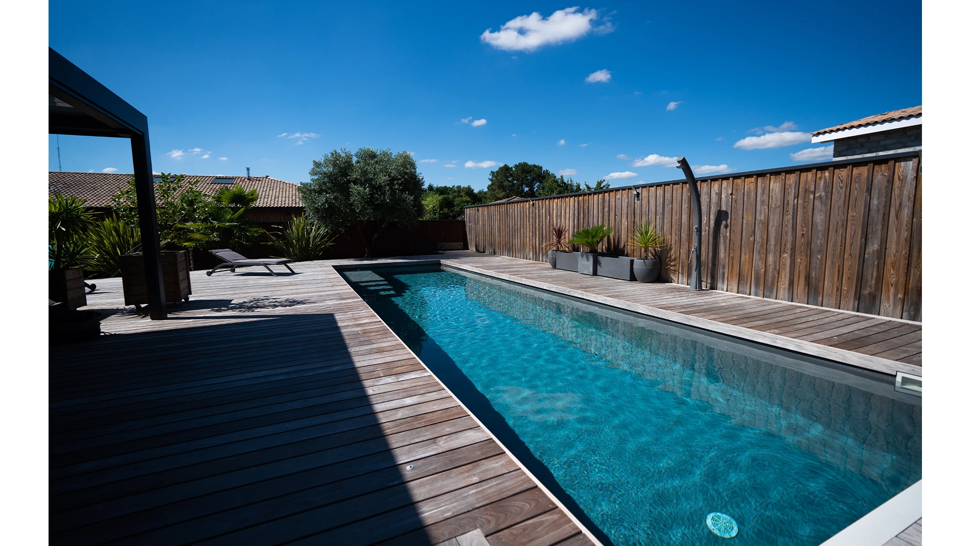piscine maconnée avec terasse en bois et liner bleu grisé